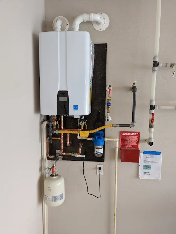 Professional plumber installing copper piping in a Huber Ridge home